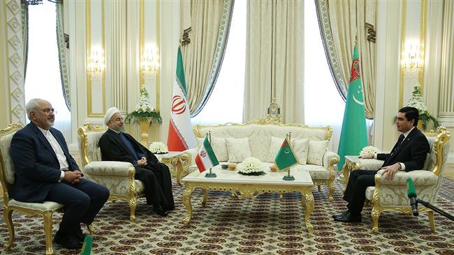 Iranian President Hassan Rouhani (2nd L) talks with his Turkmen counterpart Gurbanguly Berdimuhamedow in Ashgabat on March 11, 2015. 