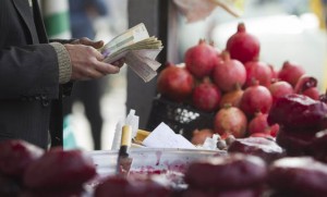 Iranian shopkeeper counts cash at a bazaar in northern Tehran
