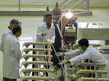 Workers move a fuels rod at the Fuel Manufacturing plant at the Isfahan Uranium Conversion Facility