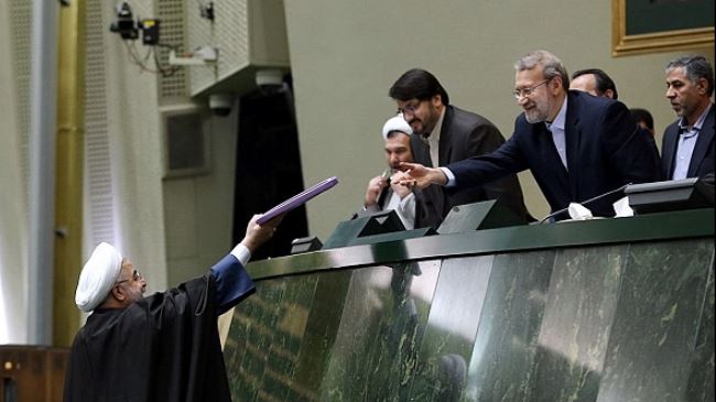 Iranian President Hassan Rouhani (L) submits the draft budget for the next Iranian fiscal year to Majlis Speaker Ali Larijani on December 7, 2014.