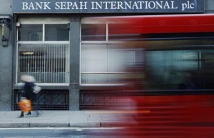 A red London bus passes a branch of Iranian owned Bank Sepah International in London
